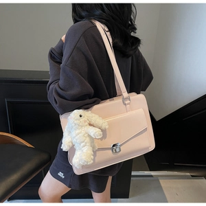 Détail du sac à main rose en cuir avec pendentif lapin en peluche et fermoir en argent