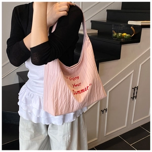 Détail du sac fourre-tout rose avec tissu texturé et slogan 'Enjoy Your Summer' imprimé