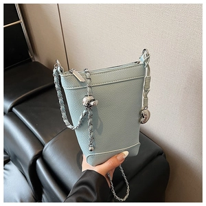 Vue détaillée du sac seau bleu clair en cuir grainé avec charm cœur et chaîne en métal