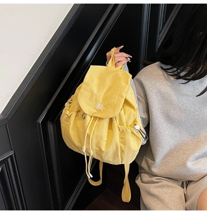 Dettaglio dello zaino da viaggio giallo in nylon con patta e tasche laterali