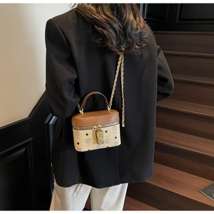 Detailed back view of a woman carrying a mini bucket bag with bear print and chain strap