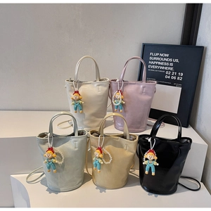 Five stylish bucket bags in various colors featuring cute doll and pearl chain charms