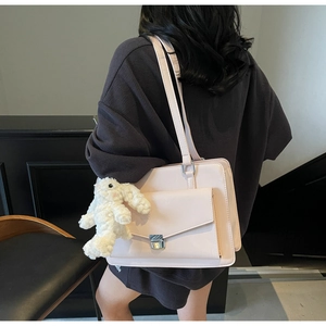 Vue détaillée du sac cabas en cuir rose clair avec fermoir argenté et breloque lapin