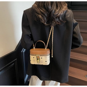 Detail of a vintage style crossbody bucket bag with bear patterns on a leather chain strap