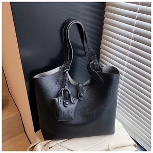 Detail of black lychee grain leather tote bag with a mini pouch and buckle closure