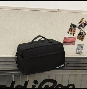 Détail du sac de voyage noir en nylon imperméable montrant le logo de la marque NOCOBAG