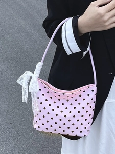 Borsa sottobraccio rosa a pois con fiocco in pizzo bianco indossata dalla modella
