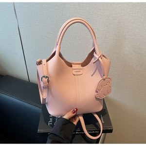 Detail of pink bucket bag featuring litchi grain leather and fashion embossed logo