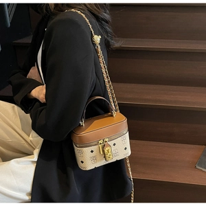 Detail view of a vintage bucket bag with monogram pattern and leather handle on stairs