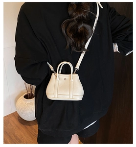 Close-up of white lychee grain leather mini handbag with detachable shoulder strap details