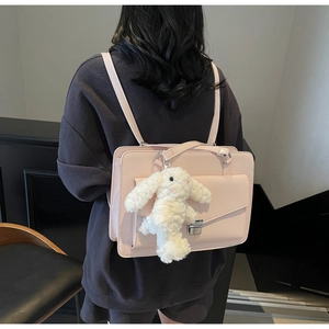 Détail de la sacoche rose clair avec breloque lapin en peluche sur un mannequin