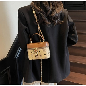 Detail of a brown and beige box-shaped bucket bag with leather chain strap and lock