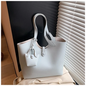 Detail of light blue tote bag in lychee grain leather with matching mini coin purse hanging