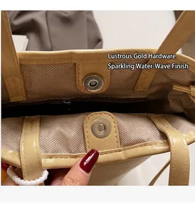 Detail van beige onderarmtas met magneetsluiting en voering met golftextuur