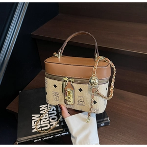 Detail of vintage box-style leather handbag featuring bear graphic and chain strap