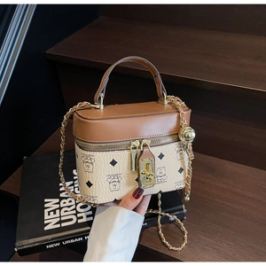 Detail of a chic bucket bag featuring a bear print pattern and golden chain strap detail