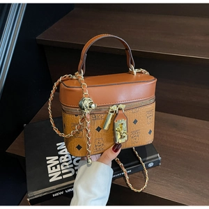 Macro detail of brown leather bucket bag featuring bear embossed pattern and chain strap