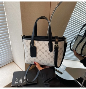 Détail du sac seau à motifs géométriques avec lanières en cuir noir et boucles dorées