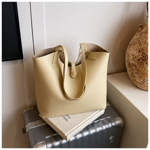 Detail of creamy yellow lychee grain leather tote bag with elegant buckle closure