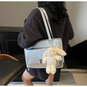 Détail du cabas argenté métallisé avec pendentif lapin en peluche et rabat élégant