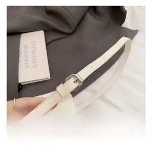 Detail of cream lychee leather shoulder strap with adjustable silver metal buckle