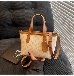 Détail du sac seau en toile avec finitions en cuir marron et motifs géométriques