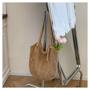Close-up of woven tote bag featuring mesh crochet texture and stylish side tassels