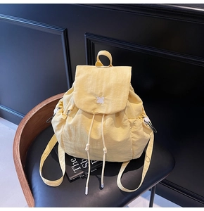 Dettaglio ravvicinato dello zaino in nylon giallo chiaro con ricamo a forma di coniglio