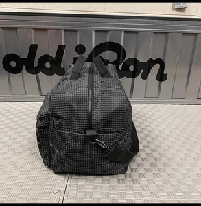 Détail du sac de voyage à carreaux noir et blanc avec sangles et boucles en métal