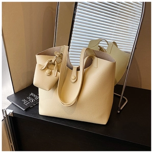 Detail view of cream yellow lychee leather tote with matching mini pouch and wide handle