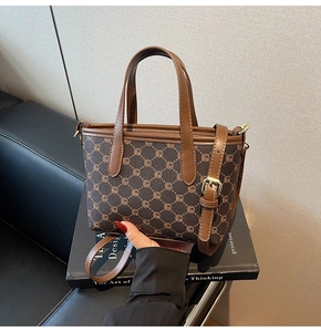 Détail d'un sac cabas à monogramme marron avec anses en cuir pour un trajet quotidien chic