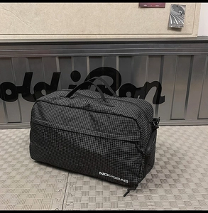 Gros plan du sac de voyage en nylon ripstop noir avec motif quadrillé et logo NOCOBAG