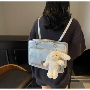 Détail du sac à dos argenté métallisé avec poche enveloppe et pendentif lapin en peluche