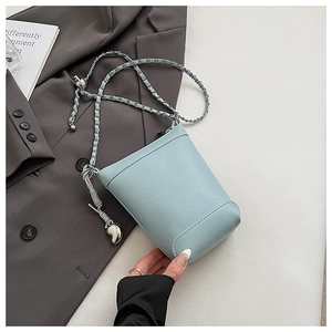 Détail du sac en cuir bleu clair à grain lychee avec bandoulière chaîne et breloque