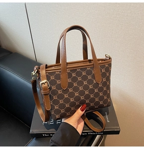 Détail d'un sac à main monogramme marron avec bandoulière sur un livre de design