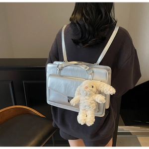 Sac à dos argenté métallisé avec peluche lapin porté par un mannequin