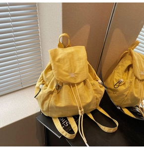 Vista dettagliata dello zaino da viaggio giallo con chiusura a coulisse e tasche laterali