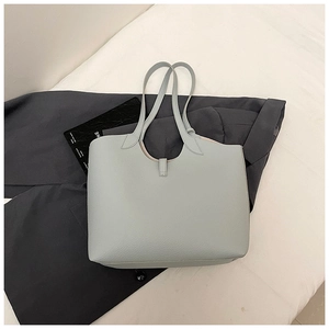 Macro shot of light blue-grey lychee grain leather tote bag with pastel pink lining