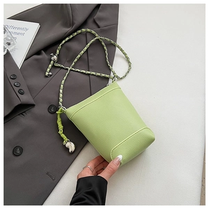 Détail du mini sac seau en cuir litchi vert citron avec breloque cœur et chaîne argent
