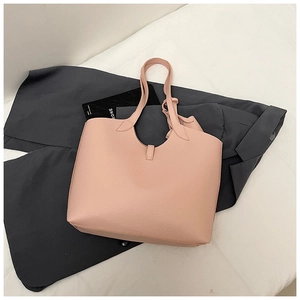 Close-up of pink litchi grain tote bag texture on grey suit, stylish office look