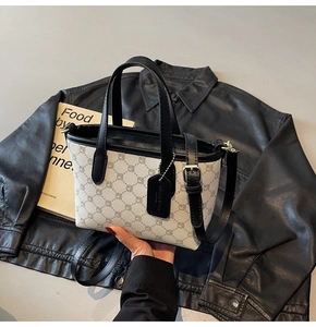 Détail du mini cabas crème avec bordure noire et motifs géométriques sur cuir