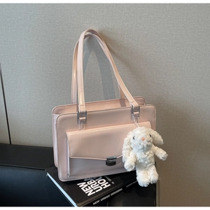 Détail du sac à bandoulière rose brillant avec boucle argentée et breloque lapin mignon
