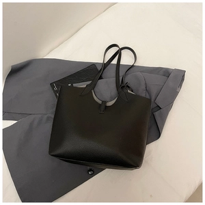 Detailed view of black litchi texture leather tote bag with U-cut design and buckle strap