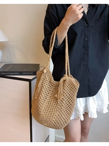 Handmade hollow straw tote bag with tassels and shoulder straps for summer beach vacations