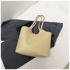Top-down view of cream tote bag showing pebbled leather texture and thin shoulder straps