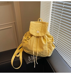 Dettaglio dello zaino in nylon giallo con ricamo animale e anello a D in metallo