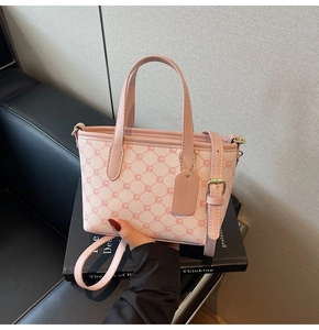 Gros plan du sac cabas rose à monogramme avec lanières en cuir et détails dorés