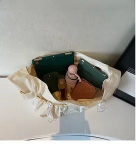 Spacious interior of the cream dumpling bag showing capacity for iPad and umbrella