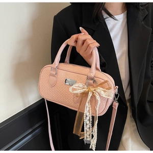 Dettaglio borsa Boston in pelle intrecciata rosa con fiocco in pizzo e logo in metallo argento