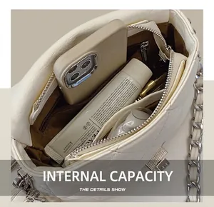 Interior view showing the large storage capacity and zipper pocket of the white quilted bag